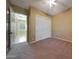 Carpeted bedroom with sliding closet doors and open doorway to tiled room at 2050 N 144Th Dr, Goodyear, AZ 85395