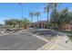 Elegant community clubhouse with lush landscaping, palm trees, and a circular driveway at 2050 N 144Th Dr, Goodyear, AZ 85395