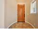 A warm and inviting entryway featuring tile flooring and wood door at 2050 N 144Th Dr, Goodyear, AZ 85395