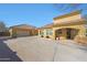 Rear view of the home showing the three car garage and desert landscaping at 2050 N 144Th Dr, Goodyear, AZ 85395