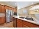Kitchen with stainless steel appliances, double sink and tiled flooring at 2050 N 144Th Dr, Goodyear, AZ 85395