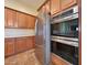 Close up of stainless steel appliances: fridge, oven, and wooden cabinets at 2050 N 144Th Dr, Goodyear, AZ 85395