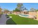 Inviting backyard pool with lush artificial turf, gazebo, bench seating, and desert landscaping at 2050 N 144Th Dr, Goodyear, AZ 85395