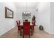 Elegant dining room with glass table and red chairs at 21041 N 61St Dr, Glendale, AZ 85308
