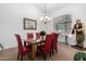 Elegant dining room with glass table and red chairs at 21041 N 61St Dr, Glendale, AZ 85308
