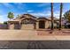Charming single-story home featuring a three-car garage, desert landscaping, and a tile roof at 21041 N 61St Dr, Glendale, AZ 85308