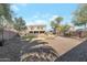 Spacious backyard featuring a mix of grass, gravel, and mature trees at 21613 N Sunset Dr, Maricopa, AZ 85139
