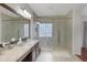 Modern bathroom featuring granite countertops, glass-enclosed shower with window, and gray tiling at 21613 N Sunset Dr, Maricopa, AZ 85139