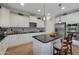 Bright kitchen with white cabinets, a large island, stainless steel appliances, and stylish pendant lighting at 21613 N Sunset Dr, Maricopa, AZ 85139
