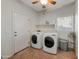 Well-lit laundry room with white washer and dryer units, and tile flooring at 21613 N Sunset Dr, Maricopa, AZ 85139