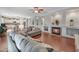 Spacious living room features a fireplace, hardwood floors, and grey sofas, with an open view into the kitchen at 21613 N Sunset Dr, Maricopa, AZ 85139