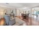 Bright living room featuring hardwood floors, modern furniture, and open layout with adjoining dining area at 21613 N Sunset Dr, Maricopa, AZ 85139