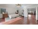 Bright main bedroom with hardwood floors, neutral tones, and an attached door to living room at 21613 N Sunset Dr, Maricopa, AZ 85139