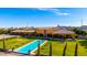 Expansive backyard with a pristine pool, lush lawn, and mature trees creating a serene outdoor space at 21962 E Diana Way, Queen Creek, AZ 85142