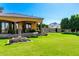 Lush backyard showcasing a water fountain, manicured lawn, and a serene setting with mountain views in the background at 21962 E Diana Way, Queen Creek, AZ 85142