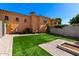 View of a backyard with a patch of artificial turf and a stone water feature at 21962 E Diana Way, Queen Creek, AZ 85142