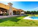 The expansive backyard with in-ground pool, manicured lawn, and stone patio area at 21962 E Diana Way, Queen Creek, AZ 85142