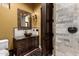 Elegant powder room featuring a decorative mirror, vessel sink, and dark wood cabinetry at 21962 E Diana Way, Queen Creek, AZ 85142