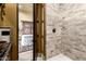 Walk-in shower with neutral tone stone tile surround and bronze hardware at 21962 E Diana Way, Queen Creek, AZ 85142