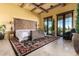 Bright bedroom with decorative rug, exposed beams, and private access to the backyard at 21962 E Diana Way, Queen Creek, AZ 85142