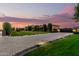 Long, patterned brick driveway leads to a luxury home with immaculate landscaping at dusk at 21962 E Diana Way, Queen Creek, AZ 85142