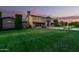 Stunning two-story home with manicured lawn and stone accents with a beautiful sunset at 21962 E Diana Way, Queen Creek, AZ 85142