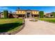 Grand two-story home with stone accents, manicured lawn, fountain and patterned brick driveway at 21962 E Diana Way, Queen Creek, AZ 85142