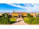 Impressive home with a lush green lawn, mature trees, and an elegant entrance, creating a welcoming curb appeal at 21962 E Diana Way, Queen Creek, AZ 85142