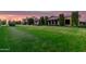 Expansive front yard with manicured lawn and mature landscaping at dusk at 21962 E Diana Way, Queen Creek, AZ 85142