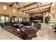 Spacious great room featuring dark leather furniture, travertine floors and high beamed ceilings at 21962 E Diana Way, Queen Creek, AZ 85142