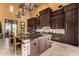Spacious kitchen features dark cabinets, a large island with granite countertops, and chandeliers at 21962 E Diana Way, Queen Creek, AZ 85142