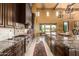 Gourmet kitchen with dark cabinets, stone backsplash, and professional grade stainless steel appliances at 21962 E Diana Way, Queen Creek, AZ 85142