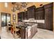 Spacious kitchen features dark cabinets, a large island with granite countertops, and chandeliers at 21962 E Diana Way, Queen Creek, AZ 85142