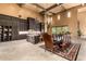 Open concept kitchen and dining area with dark wood cabinets and travertine flooring at 21962 E Diana Way, Queen Creek, AZ 85142