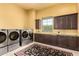 Spacious laundry room with front load washer/dryers, cabinets, and countertop at 21962 E Diana Way, Queen Creek, AZ 85142