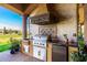 This outdoor kitchen boasts granite countertops and stainless steel appliances at 21962 E Diana Way, Queen Creek, AZ 85142