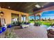 Covered outdoor patio with tiled flooring, outdoor furniture, and lush landscaping at 21962 E Diana Way, Queen Creek, AZ 85142