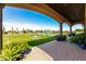 Covered patio with elegant columns, a manicured lawn, and a sparkling pool creating a serene and inviting outdoor space at 21962 E Diana Way, Queen Creek, AZ 85142