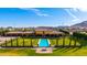 Stunning view of the pool surrounded by green space and complemented by mountain views at 21962 E Diana Way, Queen Creek, AZ 85142