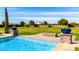 An inviting in-ground pool with a raised stone border and manicured backyard at 21962 E Diana Way, Queen Creek, AZ 85142