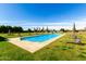 A large in-ground pool with a stone border and a beautifully maintained lawn at 21962 E Diana Way, Queen Creek, AZ 85142