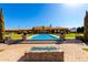 Stunning backyard with a sparkling pool, manicured lawn, and a stylish fire pit, perfect for outdoor entertaining at 21962 E Diana Way, Queen Creek, AZ 85142