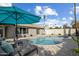 Inviting backyard pool area featuring a pool with lounge chairs, a large umbrella, and well-maintained landscaping at 2256 S Noche De Paz --, Mesa, AZ 85202