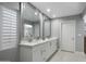 Bright bathroom features double vanity, white cabinetry, quartz countertops, and decorative mirrors at 2256 S Noche De Paz --, Mesa, AZ 85202