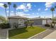 Charming single-story home featuring artificial grass, desert landscaping, and a two-car garage with mature palm trees at 2256 S Noche De Paz --, Mesa, AZ 85202