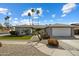 Charming single-story home featuring a desert landscape, palm trees, a two-car garage, and an arched entryway at 2256 S Noche De Paz --, Mesa, AZ 85202