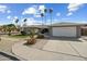 Charming single-story home featuring desert landscaping, tall palm trees, a two-car garage, and an arched entryway at 2256 S Noche De Paz --, Mesa, AZ 85202
