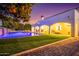 Backyard with a pool, waterfall feature, grassy lawn and citrus trees at 2458 E Melrose St, Mesa, AZ 85213