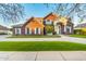 Brick home featuring arched entrance, manicured lawn, and circular driveway at 2458 E Melrose St, Mesa, AZ 85213