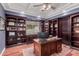 Spacious home office with custom wood built-ins and a coffered ceiling with a ceiling fan at 2458 E Melrose St, Mesa, AZ 85213